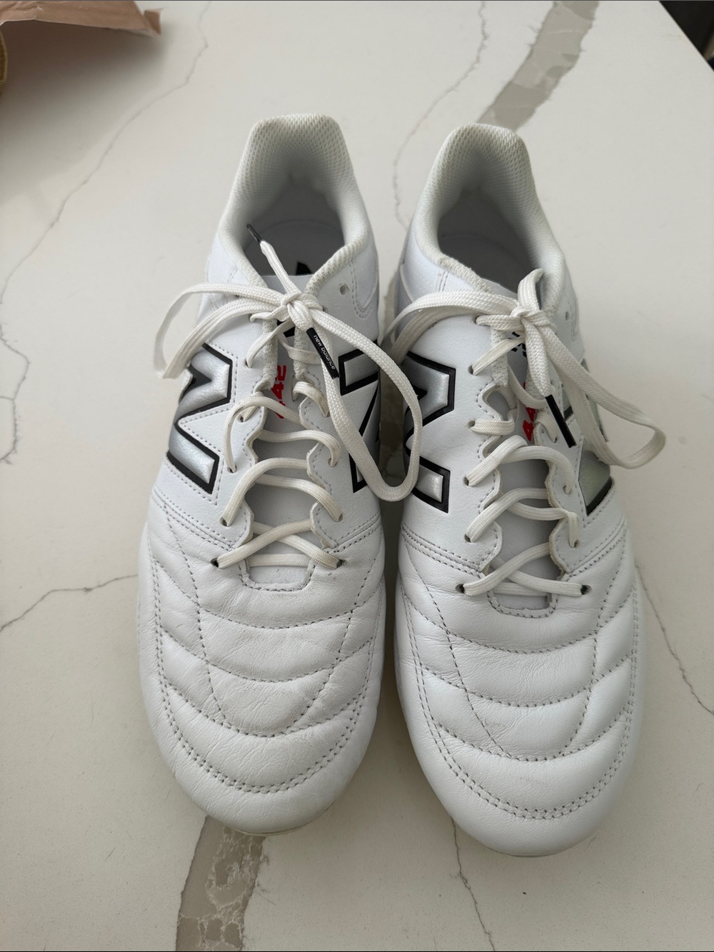 New Balance White Soccer Cleats with Black Accents and Red Detail